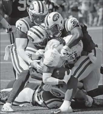  ?? BILL KOSTROUN/AP PHOTO ?? The Jets’ Doug Middleton (36), Brandon Copeland and Darron Lee tackle Miami’s Albert Wilson during the first half of Sunday’s game in East Rutherford, N.J. Miami won, 20-12.