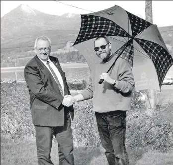  ?? 01_B11twe04 ?? Derek Shand of the Royal Bank gives Mike Lunan an umbrella as a symbol of the sponsorshi­p that the bank is providing for the annual conference of the Federation of Small Businesses at which Mike is to be a delegate from Arran.