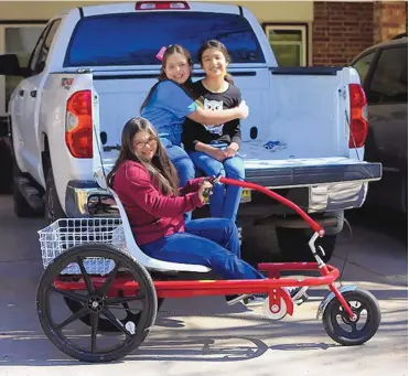  ?? BETHANY FREUDENTAL/LAS CRUCES SUN-NEWS ?? Grace Holguin sits in her special-needs tricycle next to her sisters, Eve, 9, and Sophia, 10.