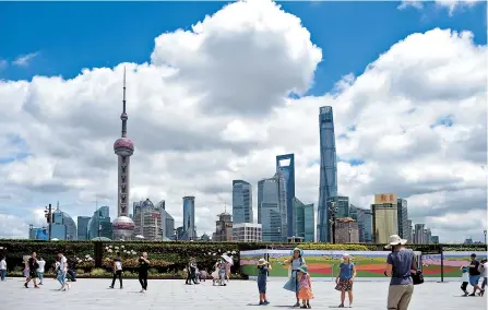  ??  ?? People enjoy the clear sunny skies on the Bund yesterday after typhoon Lekima lashed the city over the weekend. It is forecast to be mostly cloudy and hot this week. — IC