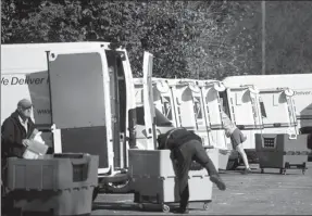  ?? MARK MAKELA / REUTERS ?? Postal workers load trucks with mail outside a post office which had been evacuated in Wilmington, Delaware, on Thursday.