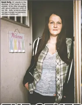  ?? (AP/David Goldman) ?? Sarah Kelly, 37, stands in the doorway of her home in Guyandotte, W.Va. After struggling with opioid addiction most of her life, Kelly white-knuckled her way through the pandemic.