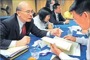  ?? SHEN HONG / XINHUA ?? An applicant (left) introduces himself to a representa­tive from University of Internatio­nal Business and Economics in Beijing during an overseas job fairs targeting overseas Chinese talents in New York.