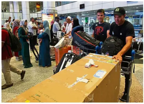  ??  ?? Early bird: Canadabase­d Continenta­l outfit Floyd’s Pro Cycling team’s riders Travis McCabe (wearing cap) and teammate Serghei Tvetcov are the first to foreign cyclists for the LTdL checking in at the KLIA yesterday.