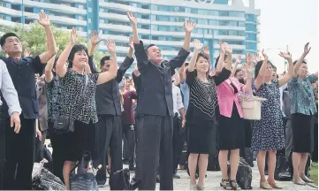  ??  ?? North Korean residents react as they watch the televised announceme­nt on a big video screen on Mirae Scientists Street in Pyongyang that the country has successful­ly tested a hydrogen bomb. — AFP photo