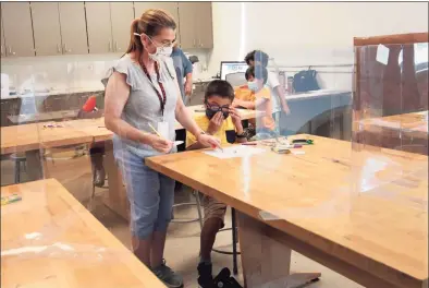  ?? Christian Abraham / Hearst Connecticu­t Media ?? Art teacher Randi Rivera helps student Byron Alvarado in an art class during summer school in Stamford in July. As the school year starts, districts are finding that a projected teacher shortage because of the pandemic mostly didn’t materializ­e.