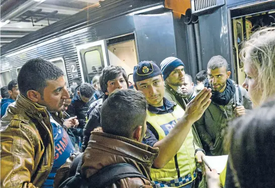  ?? PHOTO: REUTERS ?? Migrants get directions from a policeman at Malmo railway station, which has become a dumping ground for unaccompan­ied migrant children.