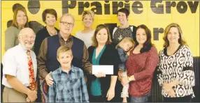  ?? LYNN KUTTER ENTERPRISE-LEADER ?? Geron Vail, of Fayettevil­le, (holding the check) donated $5,000 to Prairie Grove Elementary School to purchase books so that at-risk students can start their own home library next fall. Along with Vail are his daughters Terah Vail and Andrea Wilson and...