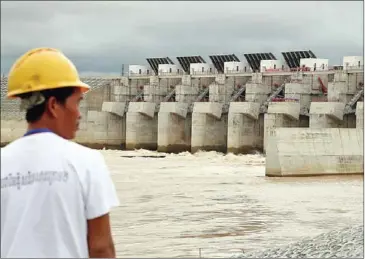  ?? HONG MENEA ?? A worker stands in front of the Lower Sesan II Dam as it went online in September in Stung Treng province.