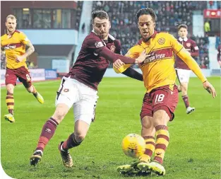  ??  ?? Hearts’ Michael Smith challenges Motherwell’s Charles Dunne for possession