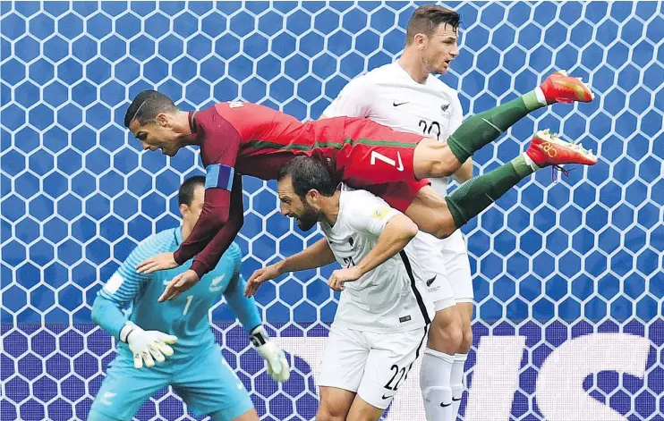  ?? — GETTY IMAGES ?? Portugal’s Cristiano Ronaldo soars over New Zealand defender Andrew Durante during Confederat­ions Cup Group A action in St. Petersburg.