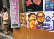  ?? Dolores Ochoa Associated Press ?? PRESIDENTI­AL campaign posters are displayed in Quito, Ecuador. Andrés Arauz, a left-wing economist, faces Guillermo Lasso, a conservati­ve businessma­n.