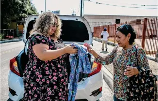  ?? ?? Azhalia Ramirez gives a summer care kit and clothes on Sept. 3 to Irma de Bautista Cervantes on West Houston Street. Ramirez distribute­d about 50 care kits in the neighborho­od that day.