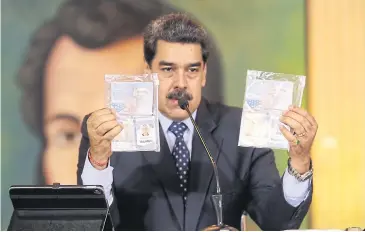  ??  ?? MARSHALLIN­G PROOF: Nicolas Maduro with the passports of two US citizens arrested during a failed sea attack.