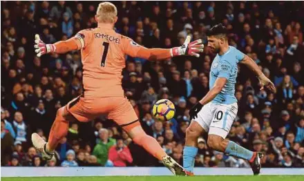  ?? AFP PIC ?? Manchester City’s Sergio Aguero scores past Leicester goalkeeper Kasper Schmeichel at the Etihad Stadium on Saturday.