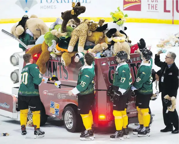  ?? GERRY KAHRMANN/PNG ?? Vancouver Giants players load teddy bears onto a Zamboni at the Pacific Coliseum on Saturday. The bears were thrown onto the ice after the Giants scored against the Victoria Royals during the annual Teddy Bear Toss.