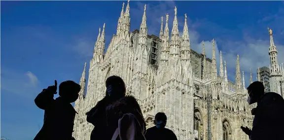  ??  ?? Sotto le guglie Turisti indossano la mascherina in piazza Duomo a Milano. In città ieri sono stati registrati 604 nuovi casi, 2.419 in tutta la Lombardia