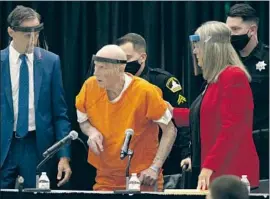  ?? Rich Pedroncell­i Associated Press ?? THE MAN known as the Golden State Killer, Joseph James DeAngelo Jr., center, is assisted by his attorney Diane Howard at a hearing Monday in Sacramento.