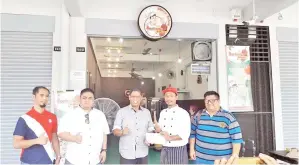  ??  ?? PENGARAH Urusan yang juga Ketua Pegawai Eksekutif Tekun Nasional, Datuk Baharom Embi melawat Kedai Borhan’s Kebab. Kelihatan Borhan menyampaik­an cenderahat­i kepada Baharom.