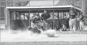 ?? AIMEE ALDEN PHOTOS ?? The Hantsport Shamrocks watched in anticipati­on as Adrian Lloy rounded third base and made a run for home plate. He slid into home in a cloud of dust as Schooners’ pitcher Justyn Newell tried to tag him out.