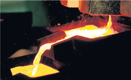  ??  ?? WORTH ITS WEIGHT: Mixed gold and silver are poured into ingot moulds at the furnace facility of Akara’s Chatree gold mine in Phichit province.