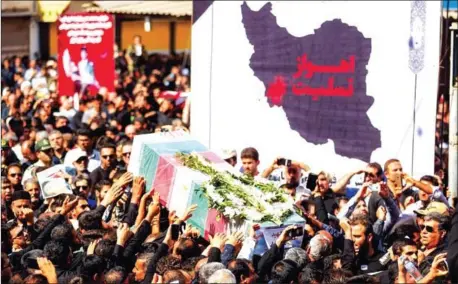  ?? ATTA KENARE/AFP ?? Iranians carry the body of one of those killed during an attack on a military parade, during a mass funeral for the victims in the southweste­rn Iranian city of Ahvaz on Monday.