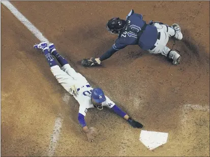  ?? DAVID J. PHILLIP — THE ASSOCIATED PRESS ?? Los Angeles Dodgers’ Mookie Betts scores past Tampa Bay Rays catcher Mike Zunino on a fielders choice by Max Muncy during the fifth