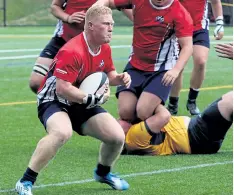  ?? PHOTO COURTESY BROCK UNIVERSITY ?? Brock's Ryan Hickey, with the ball, scored a career-high four tries as the Badgers downed the Waterloo Warriors to open the men's university rugby season Sunday in St. Catharines.