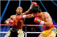  ?? — AFP file ?? Floyd Mayweather and Manny Pacquiao exchange punches during their 2015 fight in Las Vegas.