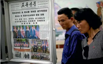  ?? AP ?? North Koreans read newspapers covering US President Donald Trump’s summit with North Korean leader Kim Jong Un at the Puhung subway station in Pyongyang.