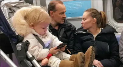  ?? AP PHOTO ?? A toddler plays with a mobile phone while riding in a New York subway in December 2017.