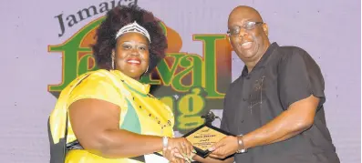  ?? CONTRIBUTE­D ?? Second-place winner in the 2019 Festival Song Competitio­n Alley Bless receives her plaque from Howard McIntosh.