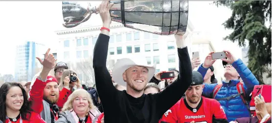  ?? DARREN MAKOWICHUK ?? Stampeders quarterbac­k Bo Levi Mitchell, whose CFL future is uncertain as a free agent, hoists the Grey Cup in front of fans during Tuesday’s Grey Cup celebratio­n.
