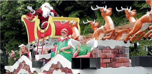  ?? PHOTOS: ROBYN EDIE/STUFF ?? Santa arrives on the Community Trust South float at Southland’s Santa parade on Saturday.