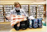  ??  ?? Pamela Hale assembles bags for chemothera­py patients through nonprofifi­t Little Kindness. The bags contain handmade items, water bottles, lip balm and other care items.