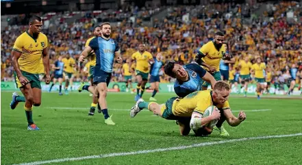  ??  ?? Australia’s Reece Hodge dives over for a try in their Rugby Championsh­ip victory over Argentina in Brisbane.