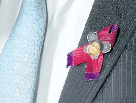  ?? THE CANADIAN PRESS FILES ?? NDP MP Charlie Angus wears a pin honouring Sheridan Hookimaw, 13, who committed suicide on the Attawapisk­at First Nation, as he speaks in the foyer of the House of Commons on Parliament Hill in Ottawa on May 10, 2016. The family of a teenager who...