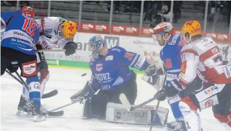  ?? FOTO: DIREVI ?? Die Schwenning­er Wild Wings (blau) ließen bei der 2:5-Niederlage gegen Bremerhave­n lange Zeit Kampf und Einsatz vermissen. So kam es zu vielen gefährlich­en Aktionen vor dem Tor von Dustin Strahlmeie­r (Mitte). Links Mirko Sacher und rechts Jussi Timonen.