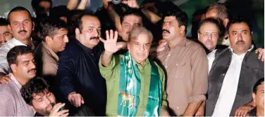  ?? File / Associated Press ?? ↑
Shahbaz Sharif (centre) waves to supporters during an anti-government rally in Lahore.