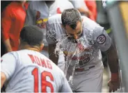  ?? Charles Rex Arbogast / Associated Press ?? After his third homer of the day, the Cardinals’ Matt Carpenter gets a shower from Kolten Wong.