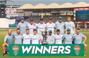  ?? AFP ?? England’s cricketers pose with the trophy after winning the Test series at the end of fourth day of third Test match against Pakistan at the National Stadium in Karachi, yesterday.