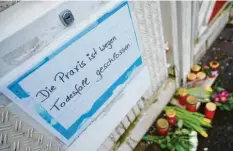  ?? Foto: Oliver Dietze, dpa ?? „Wegen Todesfall geschlosse­n“: Vor der Praxis des Arztes legten Trauernde Blumen und Kerzen nieder.