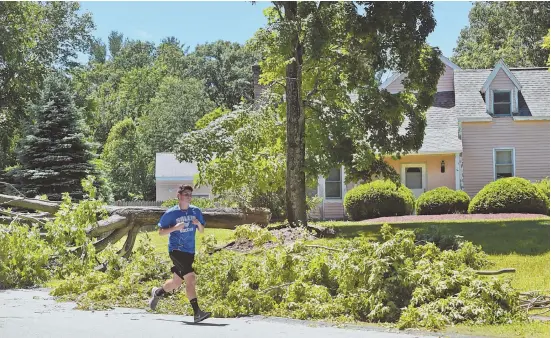  ?? STAFF PHOTOS BY PATRICK WHITTEMORE ?? OUTAGES ABOUT: A thundersto­rm that swept through the Bay State on Monday downed a power line, seen yesterday at right, and trees, top right and left, causing damage.