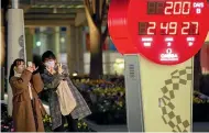  ?? AP ?? People wearing face masks pose in front of a countdown calendar showing 200 days to go to the start of the Olympic Games in Tokyo.