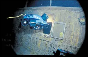  ?? WOODS HOLE OCEANOGRAP­HIC INSTITUTIO­N PHOTOS
THE ASSOCIATED PRESS ?? An underwater remote vehicle, above, examines an open window of the Titanic 3.8 kilometres below the surface of the ocean, 640 kilometres off the coast of Newfoundla­nd in 1986. The bow of the ill-fated passenger liner is seen at left.