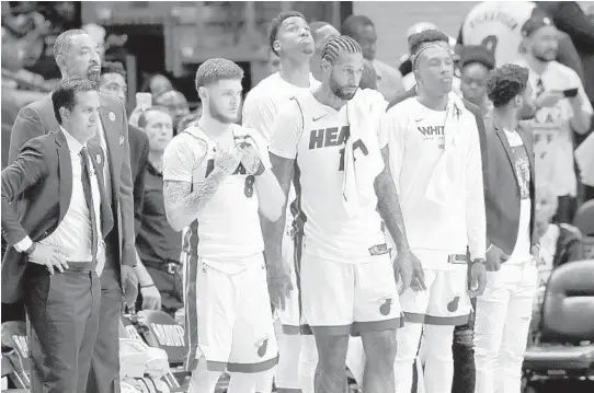  ?? LYNNE SLADKY/AP ?? Heat head coach Erik Spoelstra, left, stands with Tyler Johnson and James Johnson during the second half of Game 3 of the first-round playoff series against the Philadelph­ia 76ers on April 19 in Miami.