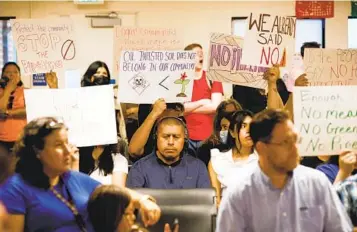  ?? KRISTIAN CARREON U-T ?? Miembros sostienen carteles de protesta contra proyecto de oleoducto de New Leaf Biofuel durante la reunión del Grupo de Planificac­ión Comunitari­a en el Museo y Centro Cultural Chicano Park en Barrio Logan.