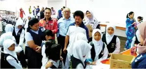  ??  ?? MOHD Fadzlee (berdiri lima kiri) bersama Guru Besar SK Batu Linting Kuala Penyu Jamawih Kanapi (empat kiri) meninjau proses pendaftara­n pelajar dari daerah Kuala Penyu yang hadir ke program itu.