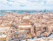  ?? DREAMSTIME ?? An aerial view of Our Lady of Mount Carmel Church and St. Paul’s Cathedral in Valletta, Malta.