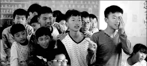  ??  ?? Students at Pingcun Middle School in Yunnan province wait in line to have their eyes checked.